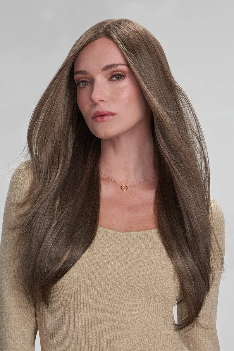 Woman with long brown hair, neutral expression.