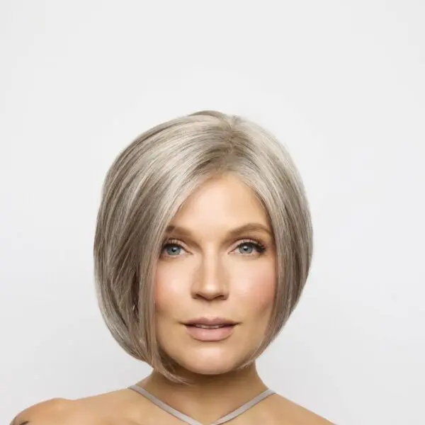 Woman with short, silver hair, neutral background.