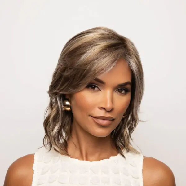 Woman with highlighted hair and gold earrings.