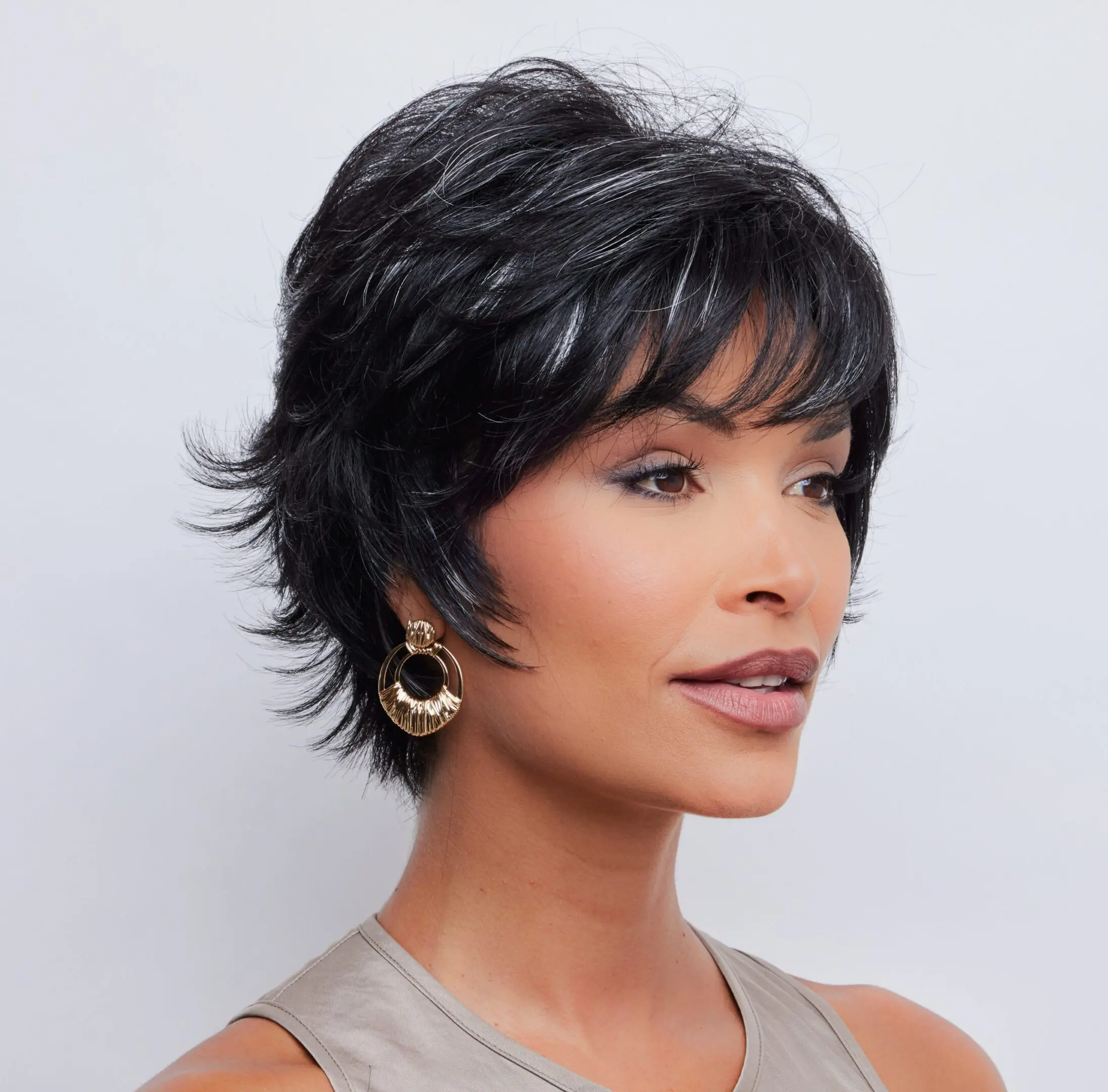Woman with short black hair, wearing earrings.