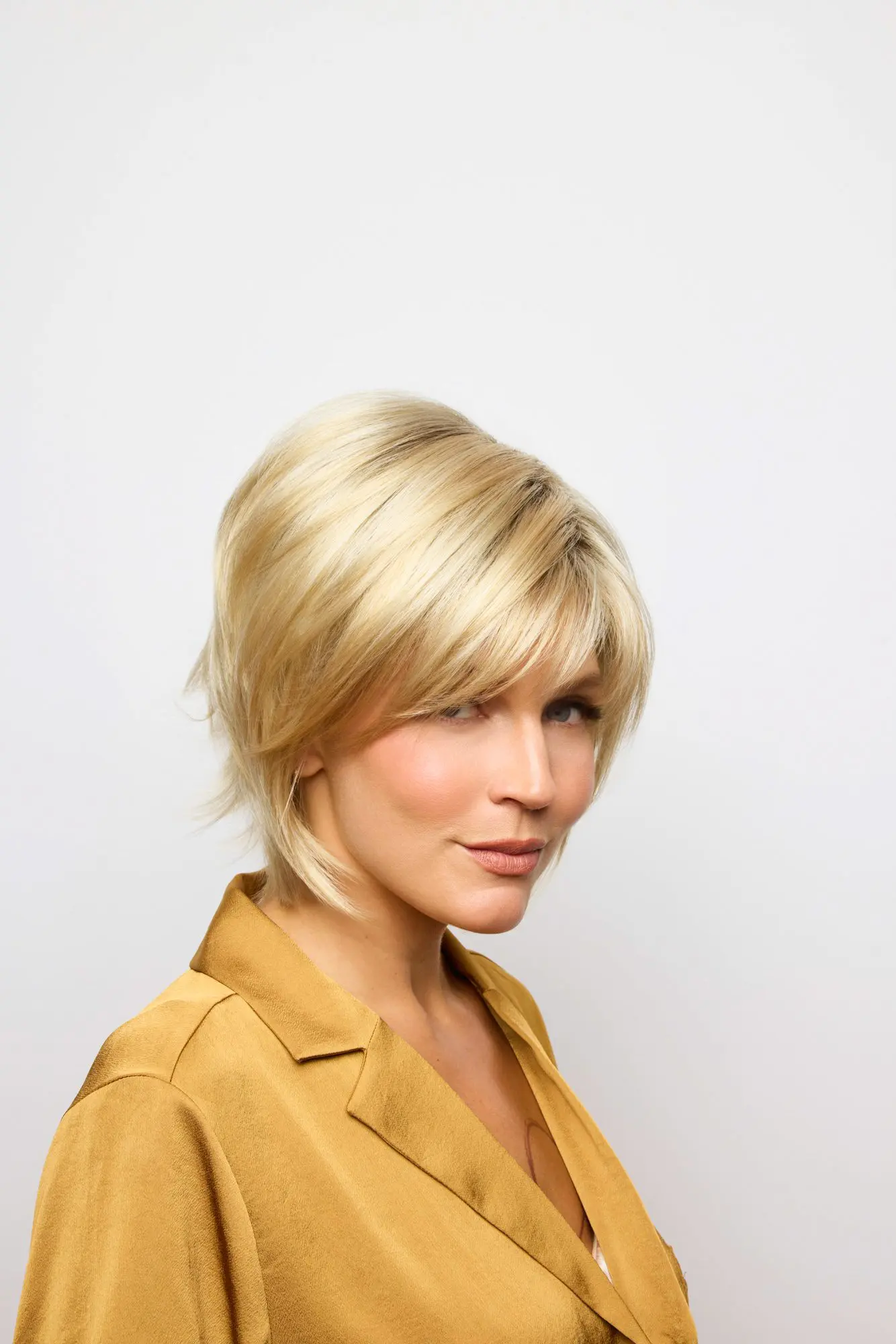 Blonde woman with short hairstyle, smiling.