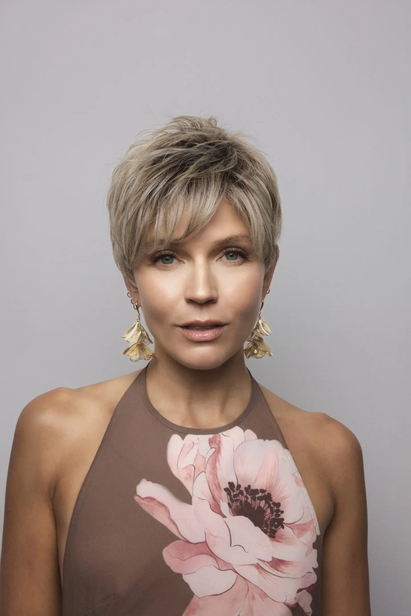Woman with short hair and floral dress.