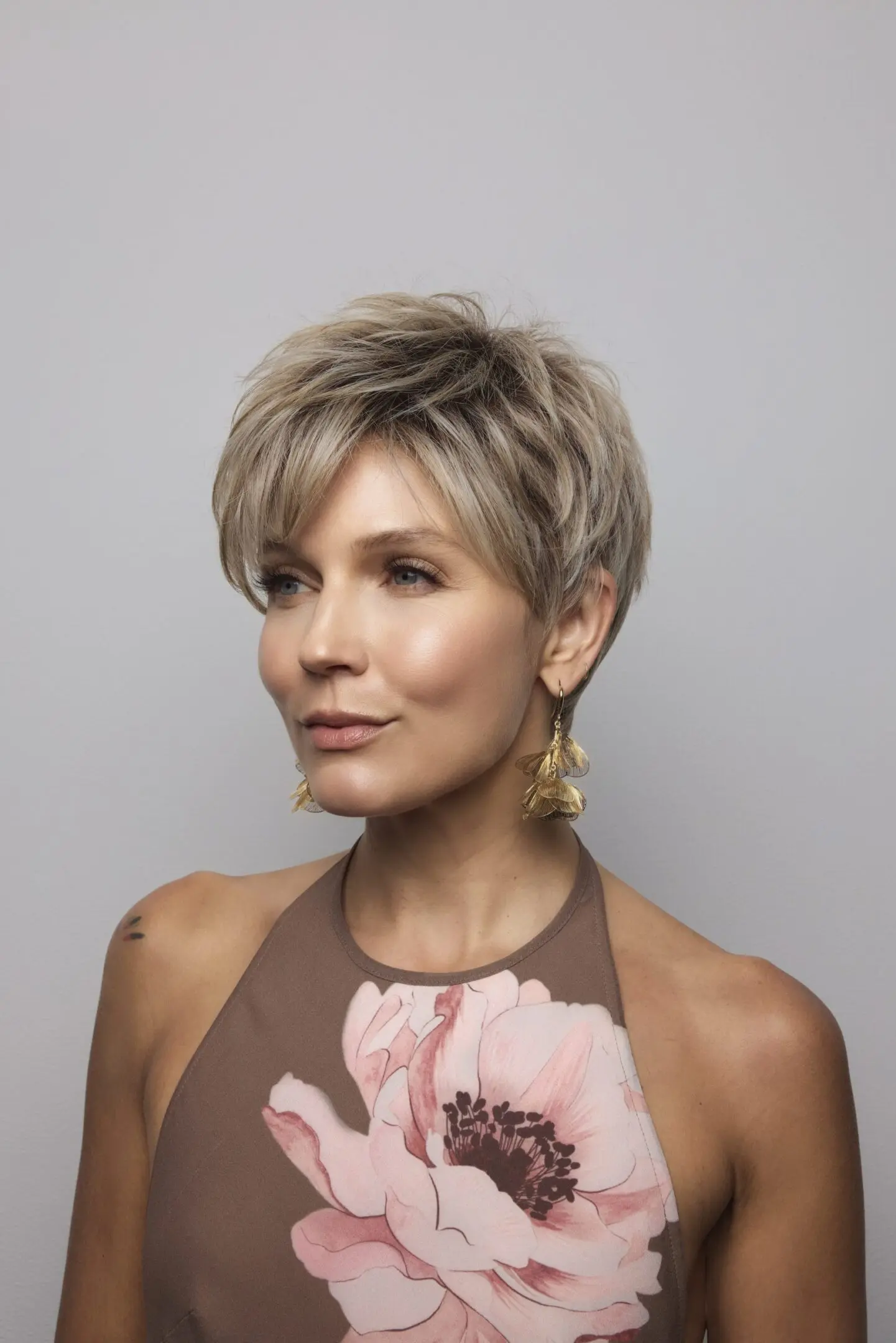 Woman with short hair and floral dress.
