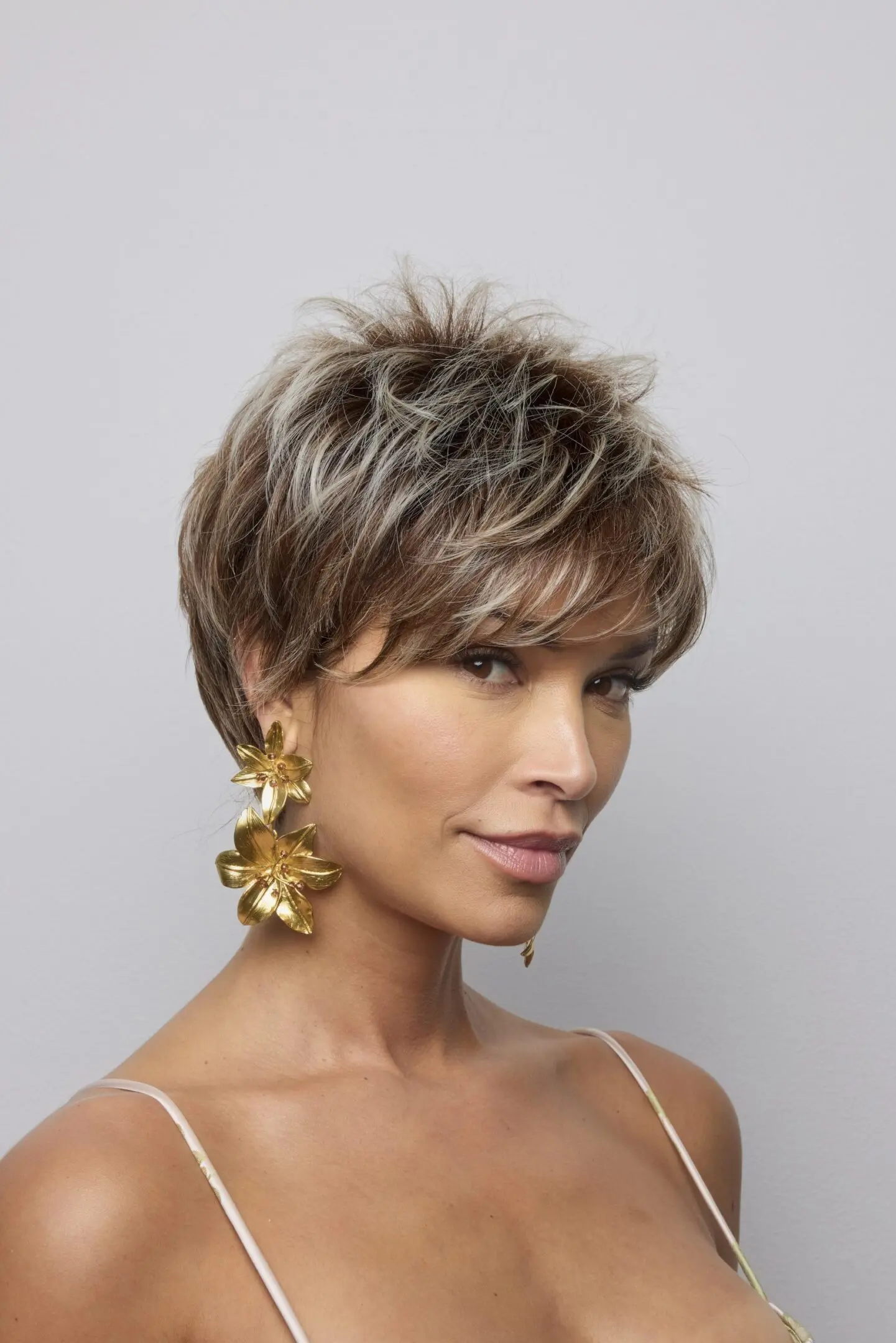 Woman with short hair and gold earrings.
